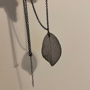 Metal leaf necklace on black chain